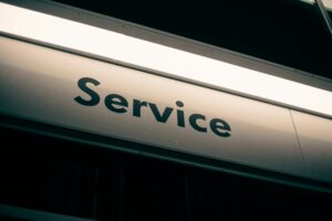 A close-up of a metallic sign with the word Service in large black letters, illuminated by overhead lighting—a fitting image for a marketing agency specializing in web site design and social media management.