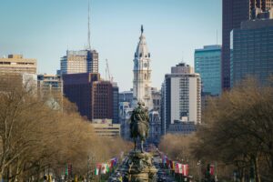 A cityscape view of Philadelphia featuring the statue of George Washington in the foreground and Philadelphia City Hall with its clock tower in the center, perfect inspiration for a marketing agency focused on web site design and digital marketing.
