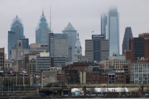 Philadelphia skyline with modern skyscrapers, historic buildings, and the top of Philadelphia City Hall visible; fog partially obscures some tall buildings in the background—an inspiring view for any marketing agency or social media management firm.