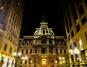 A nighttime view of a grand, ornate building with a clock tower, illuminated by bright streetlights—an inspiring cityscape perfect for digital marketing or web site design concepts.