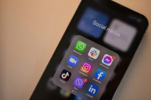 Close-up of a smartphone screen showing a folder labeled Social media with apps like WhatsApp, Slack, Messenger, Zoom, Instagram, Facebook, TikTok, Viber, and LinkedIn—essential tools for any digital marketing or marketing agency strategy.